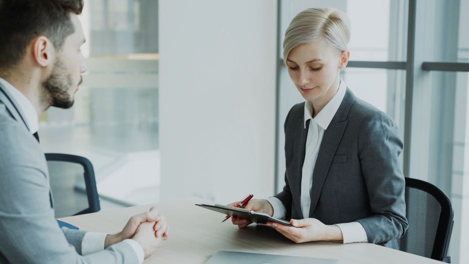Two professionals in a modern office discussing business.